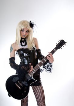 Sexy gothic girl with guitar, studio shot over white background 