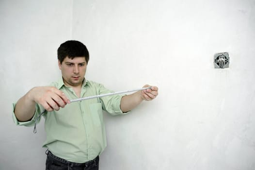 An image of a man taking measures with the tape