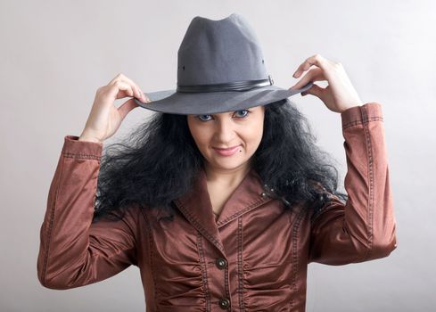 A beautiful girl holding her grey hat