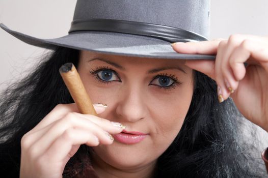 An image of a woman in felt hat with cigar
