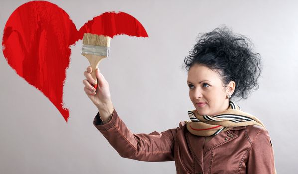 Beautiful woman drawing a red heart