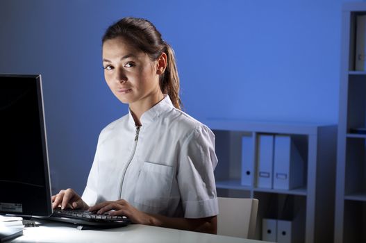 beautiful young woman doctor working at night in the office