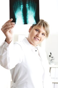 woman doctor looks at x-ray film, smile