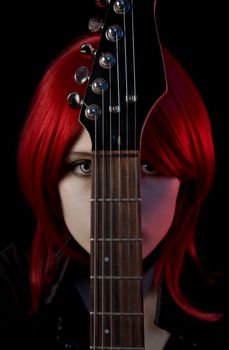 Portrait of gothic girl with guitar, selective focus on guitar, isolated on black background 