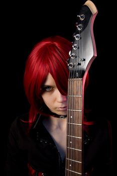 Redhead gothic girl with guitar, isolated on black background  