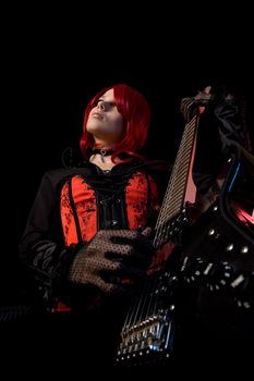 Gothic girl playing guitar, focus on corset, low angle view  