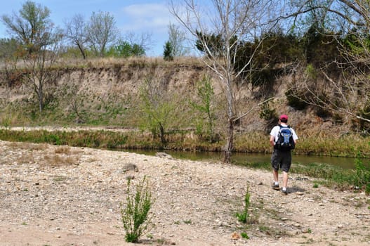 Man hikes along river background