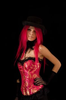 Cabaret girl in pink corset and hat with veil, isolated on black background 