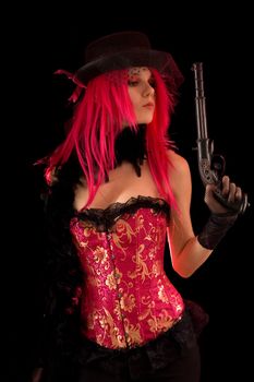 Cabaret girl in pink corset holding gun, isolated on black background 