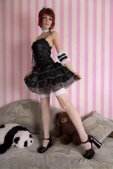 Japanese style Gothic Lolita girl with toys in funny interior 