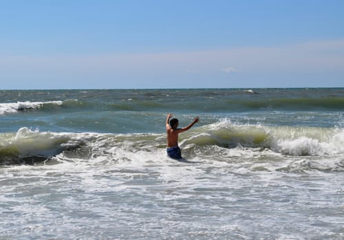 Teen playing in waves