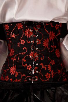 Close-up of fashionable corset with red embroidery 