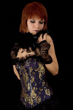 Romantic girl in blue corset with feather boa, isolated on black background 