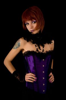 Young girl in purple corset, isolated on black background 