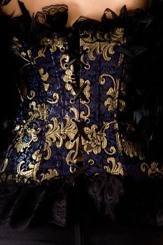 Close-up of blue corset with golden decoration    