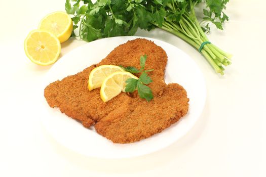 freshly roasted wiener schnitzel with lemon slices and parsley