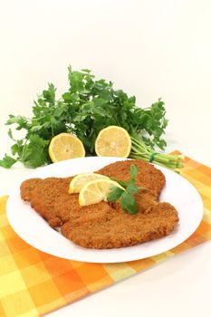 fried Wiener Schnitzel with fresh lemon slices and parsley on a napkin