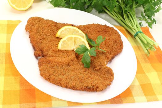 fried Wiener Schnitzel with lemon slices and parsley on a napkin