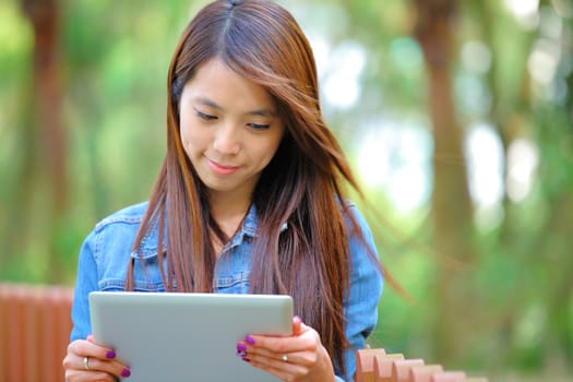 young asian woman with tablet computer outdoor
