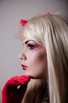 Portrait of blond cabaret girl with red glitter makeup 