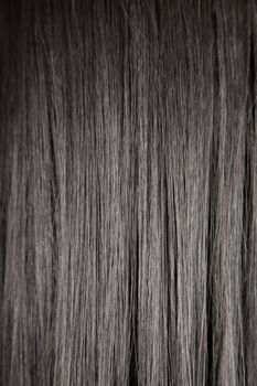 Texture of black shiny straight hair, soft focus 