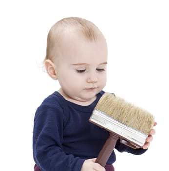 young child in blue shirt with brush on light background