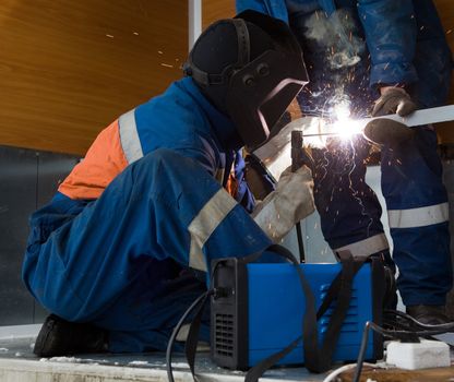 A welder working in a metal structure in the room