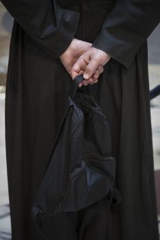 Tourist priest from behind holding his bag while looking around in the Pantheon - Rome, Italy.