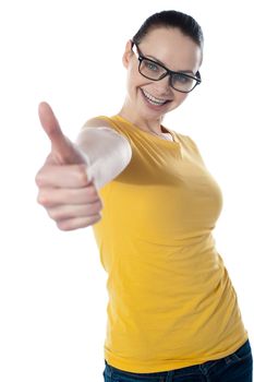 Pretty teenager showing thumbs-up wearing glasses