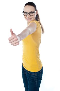 Glamourous teenager gesturing thumbs-up isolated on white