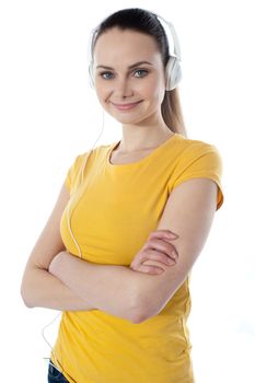 Young girl listening to music posing with folded arms