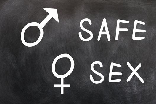 Safe Sex with gender symbols written with chalk on a blackboard