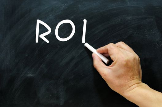 Acronym of ROI written on a Blackboard / chalkboard 