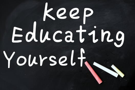 Acronym of KEY for Keep Education Yourself written with chalk on a blackboard