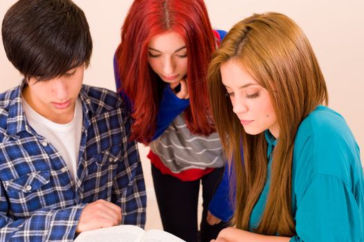 Three students working together over a book