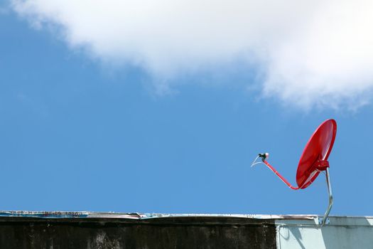 isolated red satellite on sunny blue sky