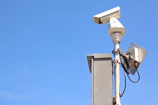 isolated Surveillance Security Camera or CCTV on blue sky, right perspective