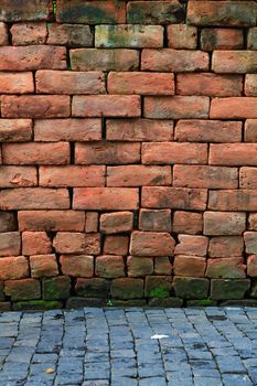 irregular shapes of red stone brick wall with pavement, vertical