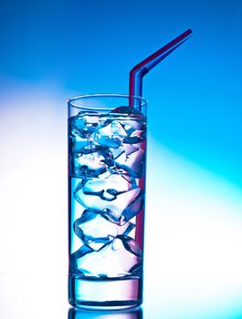 Glass of clear cocktail filled with ice cubes