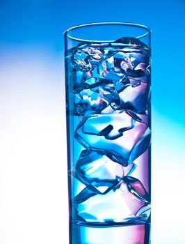 Glass of clear cocktail filled with ice cubes