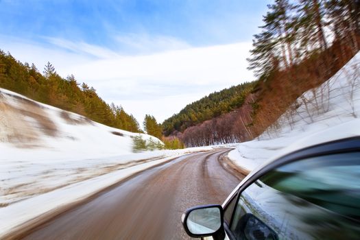 car moves along the winding roads of winter. Winter Landscape, motion blur.