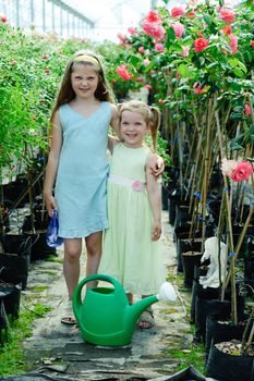 An image of two little sisters in a greenhouse