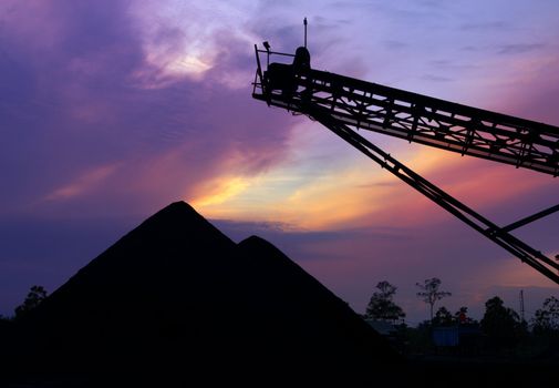 Mining landscape silhouette of coal stock at sunrise