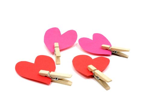 Four hearts with wooden pins on each heart on white background