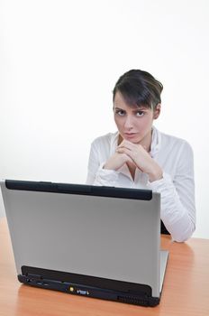 Serious executive sitting in front of laptop 