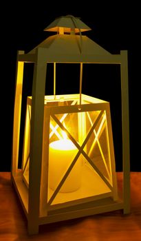 A decorative white lantern with a lit candle