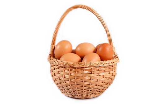 wicker basket with brown eggs on a white background