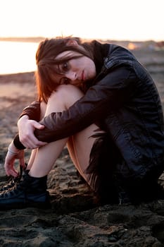 Sad model on the beach at sunset thinking