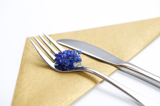 Fork and knife decorated with a blue lavender and gold napkin. Clean and elegant