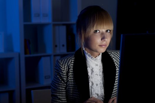 beautiful young business woman working at night in the office